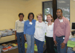 Photo of volunteers including Ginny Royal standing in a row smiling at Carpenter's Shelter.